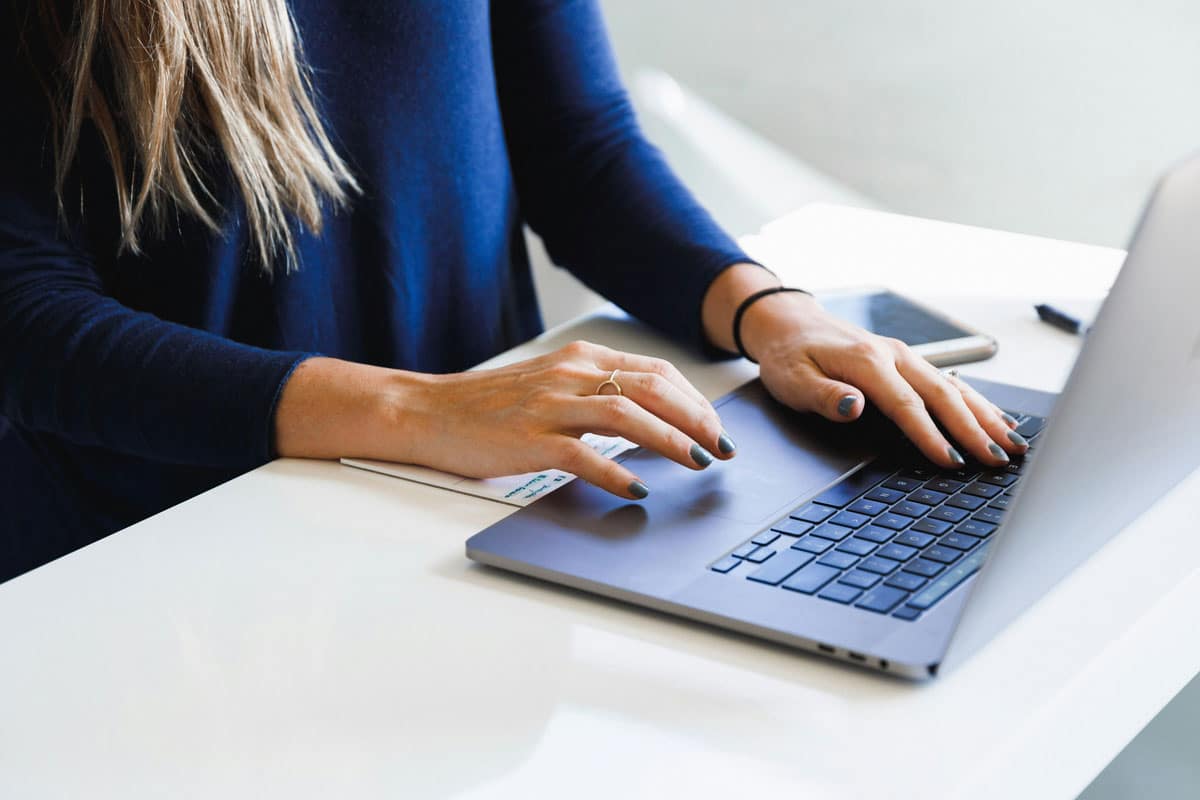 Woman typing ob keyboard creating website content