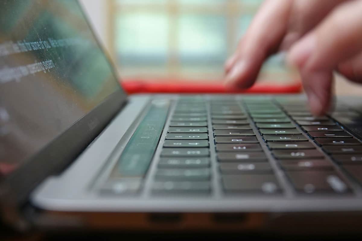 Man typing on a laptop creating website content